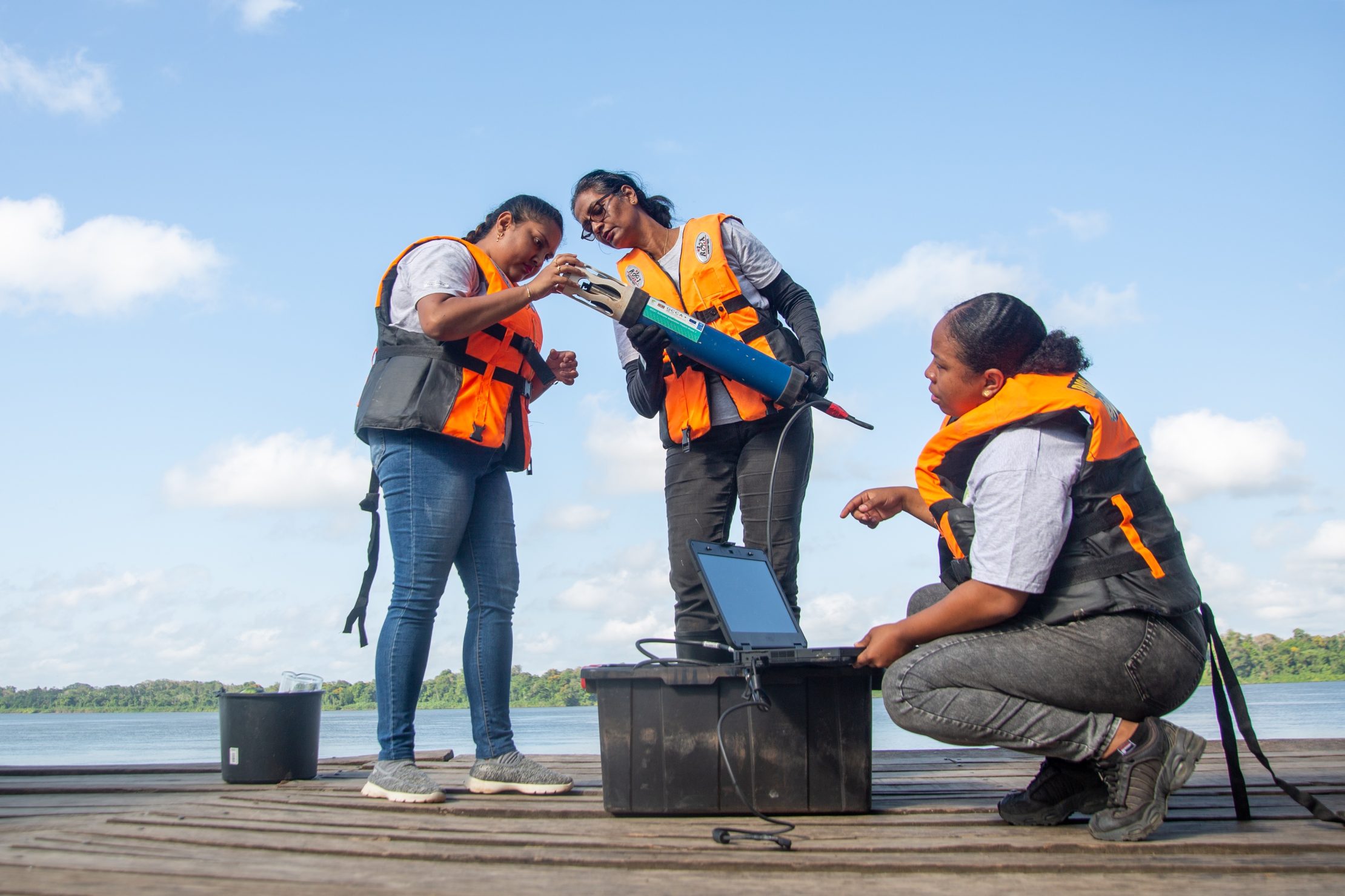 Women conducting water quality measurements as part of an initiative training women officers to lead in environmental management in Suriname. 